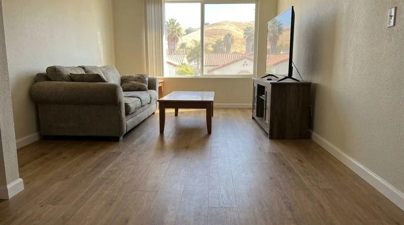 Same living room with new premium plank flooring and repaired walls after restoration